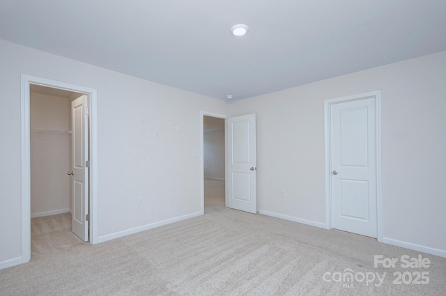 427 Carolina Hemlock Dr, Locust, NC 28097 - unfurnished bedroom with carpet flooring, a walk in closet, and baseboards
