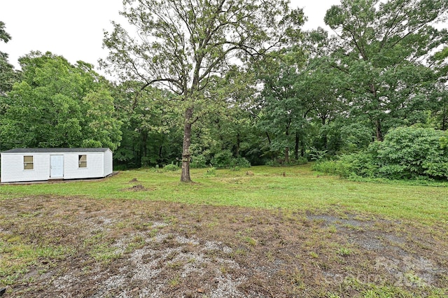 5222 Sikes Mill Rd, Monroe, NC 28110 - view of grassy yard featuring an outbuilding and a wooded view