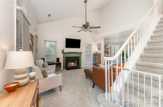 8624 Canter Post Dr, Charlotte, NC 28216 - carpeted living area featuring high vaulted ceiling, a fireplace with flush hearth, stairway, and ceiling fan