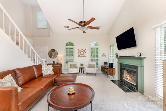 8624 Canter Post Dr, Charlotte, NC 28216 - living room with carpet floors, stairway, a fireplace, a ceiling fan, and high vaulted ceiling