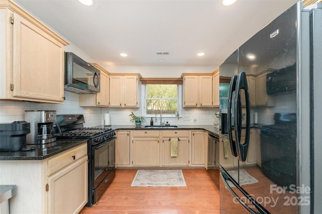8624 Canter Post Dr, Charlotte, NC 28216 - kitchen featuring black appliances, a sink, light brown cabinets, light wood-type flooring, and dark countertops