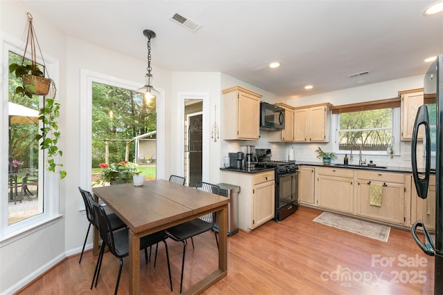 8624 Canter Post Dr, Charlotte, NC 28216 - kitchen with black appliances, decorative backsplash, light brown cabinetry, plenty of natural light, and recessed lighting