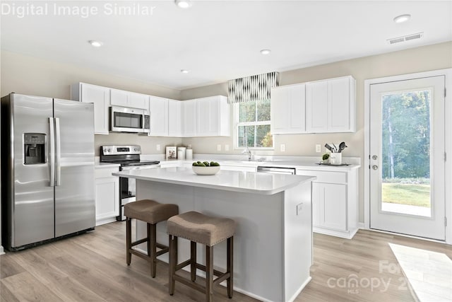 10108 Florentine Way, Charlotte, NC 28214 - kitchen with appliances with stainless steel finishes, white cabinets, light countertops, a kitchen island, and a sink
