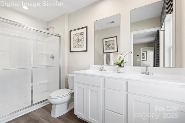 10108 Florentine Way, Charlotte, NC 28214 - bathroom featuring toilet, double vanity, a shower stall, and wood finished floors