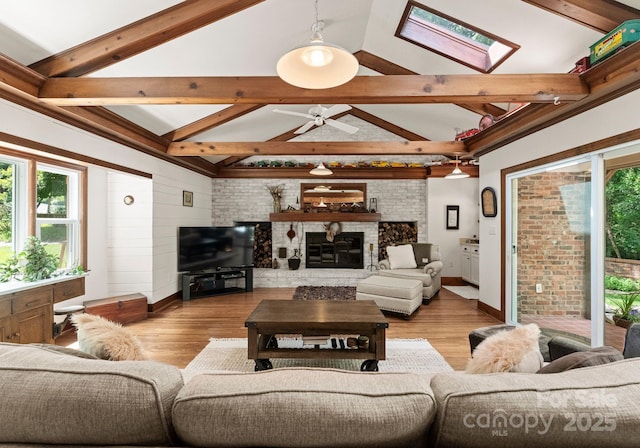 1226 Tarrington Ave, Charlotte, NC 28205 - living area featuring healthy amount of natural light, a skylight, a large fireplace, and ceiling fan
