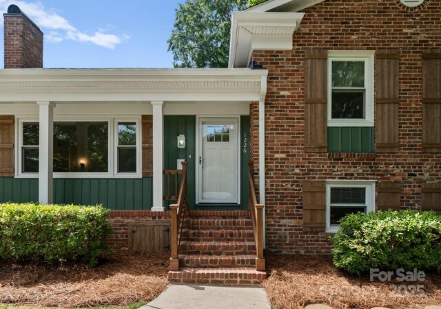 1226 Tarrington Ave, Charlotte, NC 28205 - doorway to property featuring brick siding, a chimney, and board and batten siding