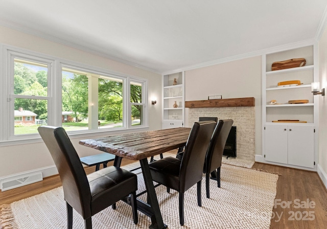 1226 Tarrington Ave, Charlotte, NC 28205 - dining space with healthy amount of natural light, light wood finished floors, built in features, baseboards, and ornamental molding