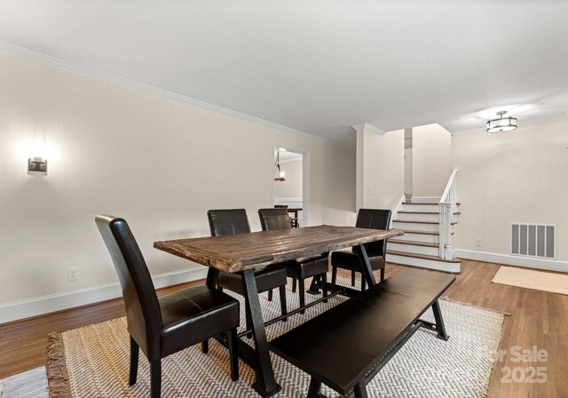 1226 Tarrington Ave, Charlotte, NC 28205 - dining space with crown molding, wood finished floors, baseboards, and stairs