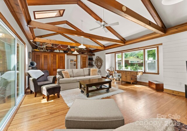 1226 Tarrington Ave, Charlotte, NC 28205 - living room featuring light wood finished floors, a ceiling fan, baseboards, and wooden walls