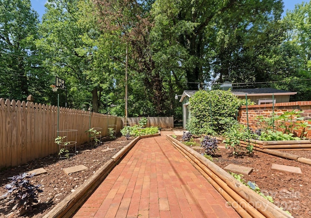 1226 Tarrington Ave, Charlotte, NC 28205 - wooden terrace featuring a garden, a fenced backyard, and view of wooded area