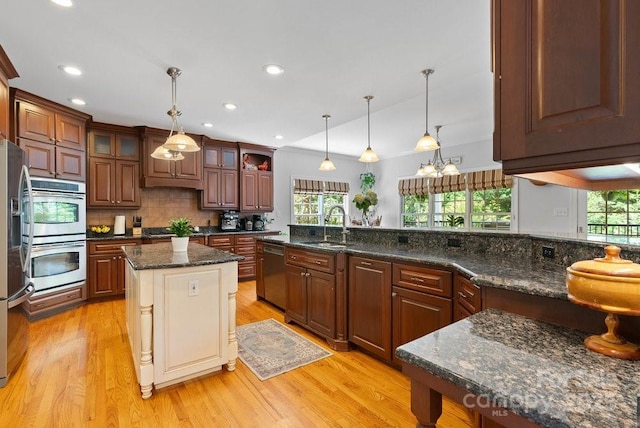 134 Brightmore Cir, Rutherfordton, NC 28139 - kitchen featuring appliances with stainless steel finishes, a sink, light wood finished floors, glass insert cabinets, and tasteful backsplash