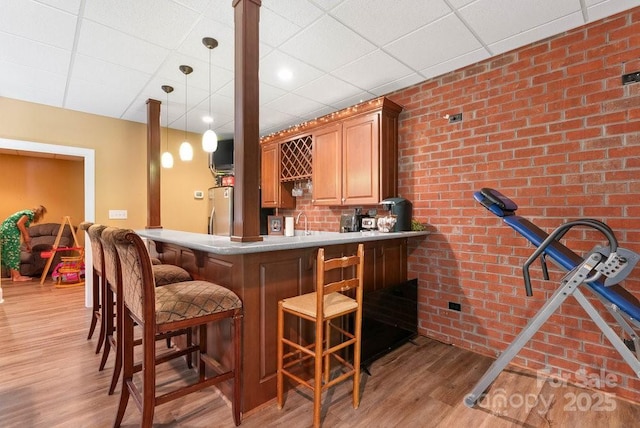 134 Brightmore Cir, Rutherfordton, NC 28139 - indoor wet bar with freestanding refrigerator, light wood-style flooring, brick wall, decorative light fixtures, and a paneled ceiling