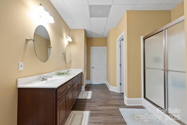 134 Brightmore Cir, Rutherfordton, NC 28139 - bathroom with double vanity, a shower with door, wood finished floors, a paneled ceiling, and baseboards