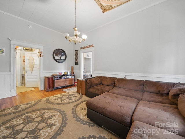 211 S Rowan Ave, Spencer, NC 28159 - living area with ornamental molding, wood finished floors, a chandelier, a wainscoted wall, and vaulted ceiling