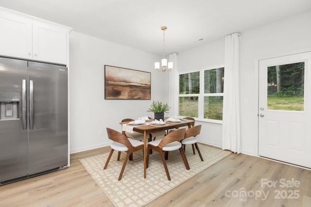 1815 Wildwood Dr, Charlotte, NC 28214 - dining room with light wood-style floors, a chandelier, and baseboards