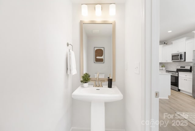 1815 Wildwood Dr, Charlotte, NC 28214 - bathroom featuring tasteful backsplash and wood finished floors