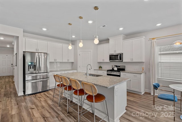 1344 Sweet Pea St, Monroe, NC 28110 - kitchen with stainless steel appliances, a sink, light wood-style floors, decorative backsplash, and recessed lighting