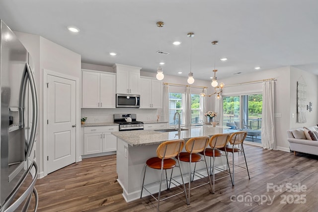 1344 Sweet Pea St, Monroe, NC 28110 - kitchen with appliances with stainless steel finishes, a sink, wood finished floors, light stone counters, and recessed lighting