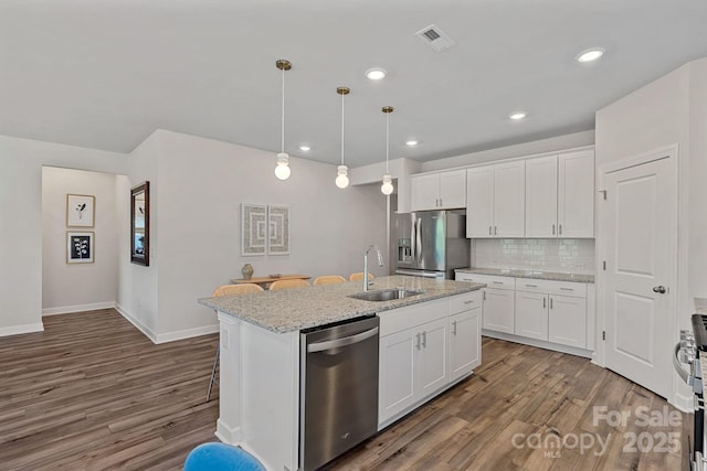 1344 Sweet Pea St, Monroe, NC 28110 - kitchen with appliances with stainless steel finishes, a sink, wood finished floors, a kitchen island with sink, and recessed lighting