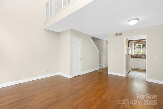 6101 Heath Ridge Ct, Charlotte, NC 28210 - unfurnished living room with wood finished floors, stairs, a sink, and baseboards