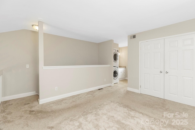6101 Heath Ridge Ct, Charlotte, NC 28210 - unfurnished bedroom featuring stacked washer / drying machine, carpet floors, a closet, baseboards, and lofted ceiling