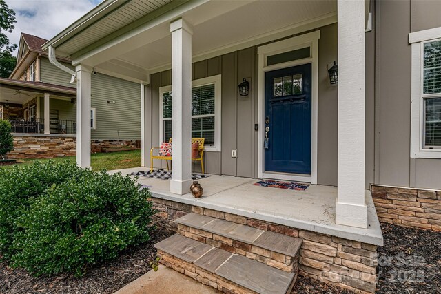 360 Sundown Rd, Mooresville, NC 28117 - doorway to property with a porch, board and batten siding, and stone siding