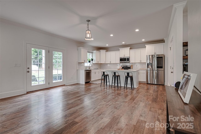 360 Sundown Rd, Mooresville, NC 28117 - kitchen featuring stainless steel appliances, ornamental molding, a sink, light countertops, and decorative backsplash