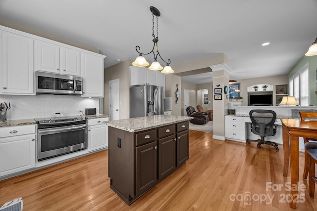 10703 Back Ridge Rd, Charlotte, NC 28277 - kitchen with stainless steel appliances, open floor plan, white cabinetry, light wood finished floors, and recessed lighting