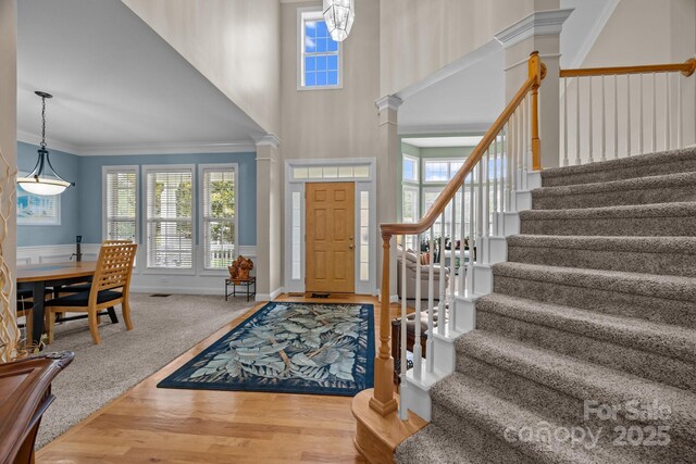 10703 Back Ridge Rd, Charlotte, NC 28277 - entrance foyer featuring ornate columns, stairs, crown molding, wood finished floors, and a high ceiling