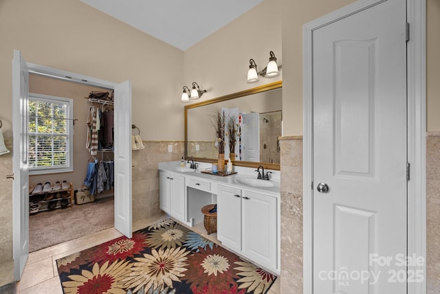 10703 Back Ridge Rd, Charlotte, NC 28277 - bathroom with double vanity, tile walls, a tile shower, a wainscoted wall, and tile patterned floors