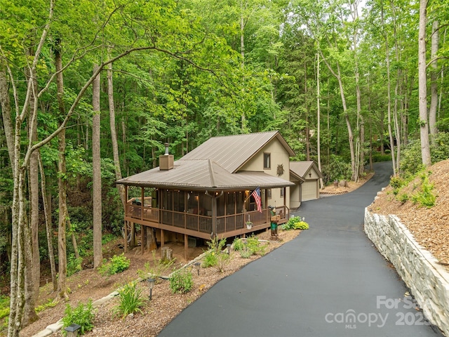 141 Creekside Dr, Maggie Valley, NC 28751 - view of front of property featuring a wooded view, a chimney, metal roof, and a porch
