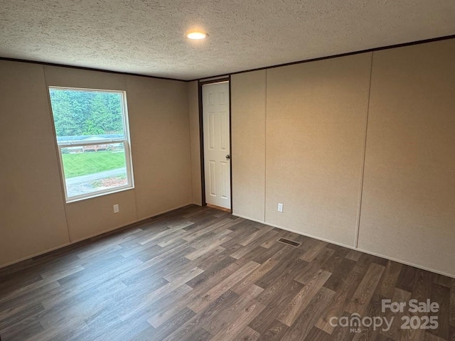 3162 Bear Trail Dr, Lenoir, NC 28645 - unfurnished bedroom with dark wood-style flooring and a textured ceiling