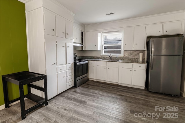 901 Echo Glen Rd, Charlotte, NC 28213 - kitchen featuring appliances with stainless steel finishes, a sink, dark countertops, white cabinets, and dark wood finished floors