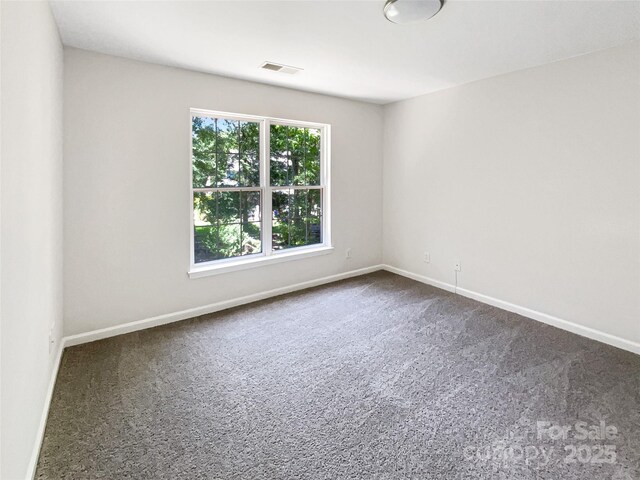 6413 Fillian Ln, Charlotte, NC 28269 - empty room with dark colored carpet and baseboards