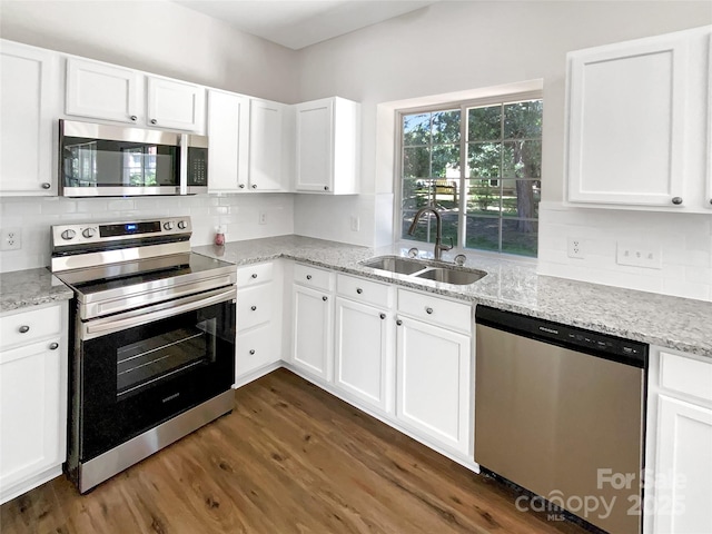 6413 Fillian Ln, Charlotte, NC 28269 - kitchen featuring appliances with stainless steel finishes, a sink, dark wood-style flooring, white cabinets, and light stone countertops