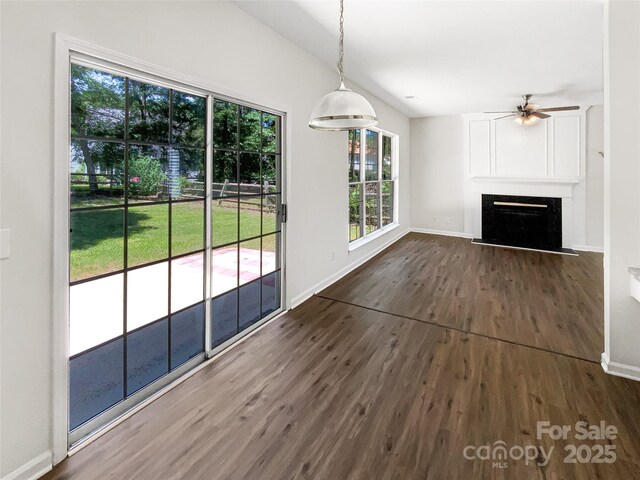 6413 Fillian Ln, Charlotte, NC 28269 - unfurnished living room with dark wood-style flooring, a ceiling fan, baseboards, and a fireplace