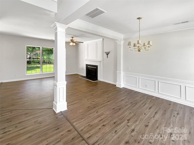 6413 Fillian Ln, Charlotte, NC 28269 - unfurnished living room featuring ornate columns, a fireplace with raised hearth, dark wood-style flooring, a chandelier, and a ceiling fan