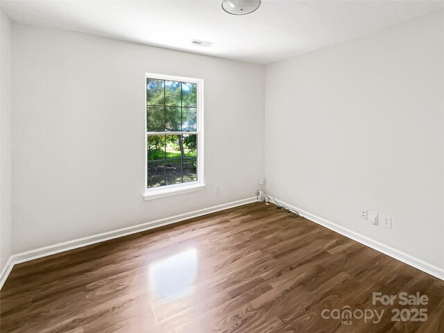 6413 Fillian Ln, Charlotte, NC 28269 - empty room featuring dark wood-style floors and baseboards