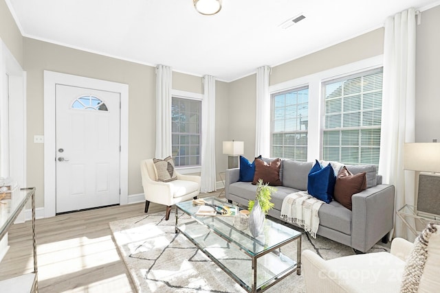 210 E 5th Ave, Gastonia, NC 28054 - living room featuring wood finished floors, healthy amount of natural light, ornamental molding, and baseboards