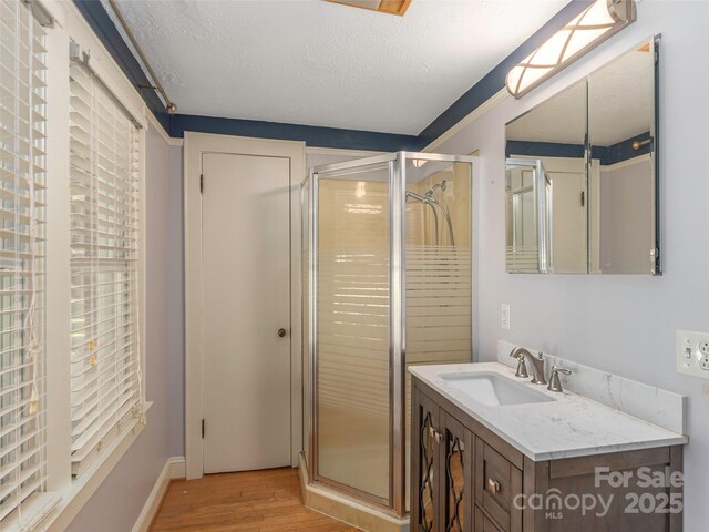 78 Hardin Ln, Clyde, NC 28721 - bathroom featuring a stall shower, wood finished floors, vanity, a textured ceiling, and baseboards