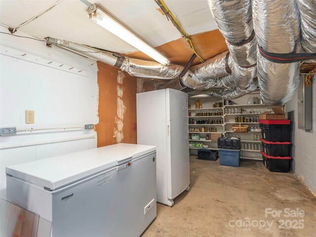 78 Hardin Ln, Clyde, NC 28721 - unfinished basement featuring freestanding refrigerator, electric panel, and refrigerator