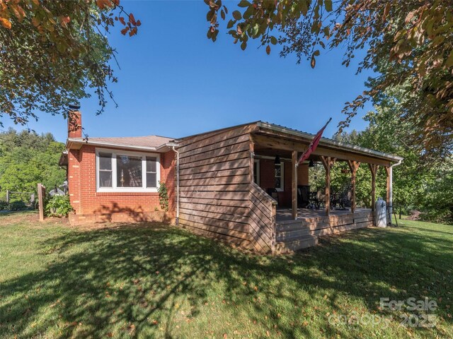 78 Hardin Ln, Clyde, NC 28721 - view of front of house with a front yard, a chimney, and brick siding