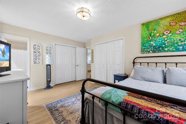 122 Pratt St, Belmont, NC 28012 - bedroom featuring light wood finished floors, a textured ceiling, baseboards, and two closets