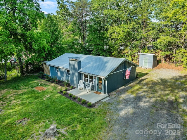 28 Reynolds School Rd, Asheville, NC 28803 - mid-century modern home with a patio, metal roof, a front yard, and driveway