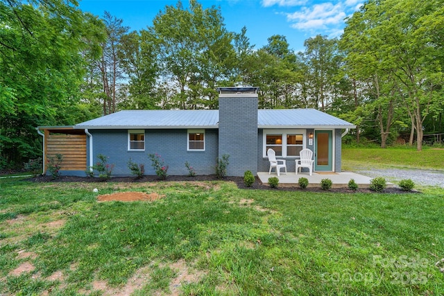 28 Reynolds School Rd, Asheville, NC 28803 - view of front of home with metal roof, a front yard, a chimney, and brick siding
