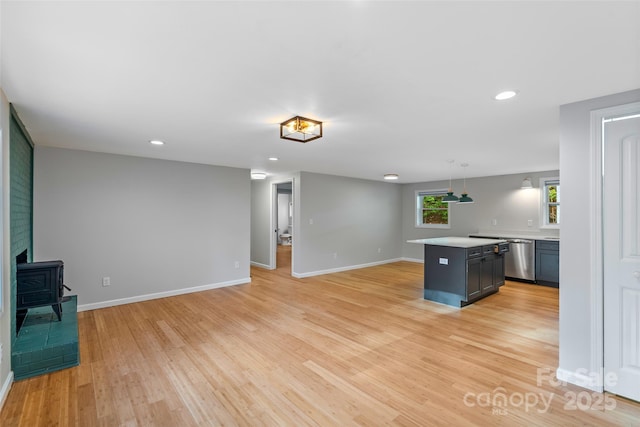 28 Reynolds School Rd, Asheville, NC 28803 - kitchen featuring a wood stove, light countertops, light wood-style flooring, dishwasher, and baseboards