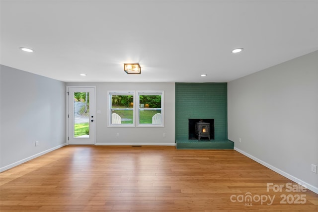 28 Reynolds School Rd, Asheville, NC 28803 - unfurnished living room featuring a wood stove, light wood-type flooring, recessed lighting, and baseboards