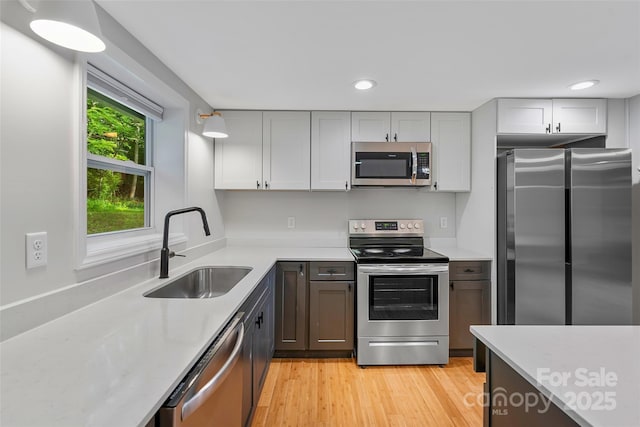 28 Reynolds School Rd, Asheville, NC 28803 - kitchen with stainless steel appliances, a sink, light countertops, recessed lighting, and light wood-style flooring