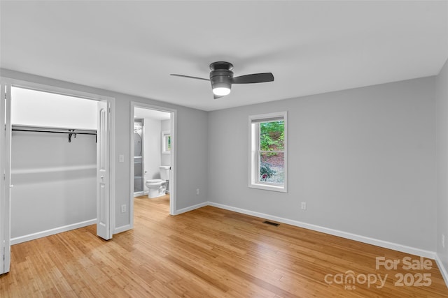 28 Reynolds School Rd, Asheville, NC 28803 - unfurnished bedroom with light wood finished floors, baseboards, a closet, ensuite bathroom, and a ceiling fan