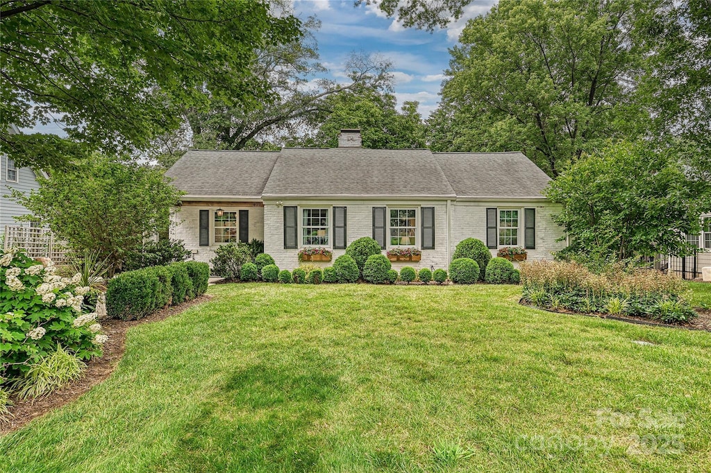 829 Sedgefield Rd, Charlotte, NC 28209 - view of front of home with brick siding, a front yard, a chimney, and a shingled roof
